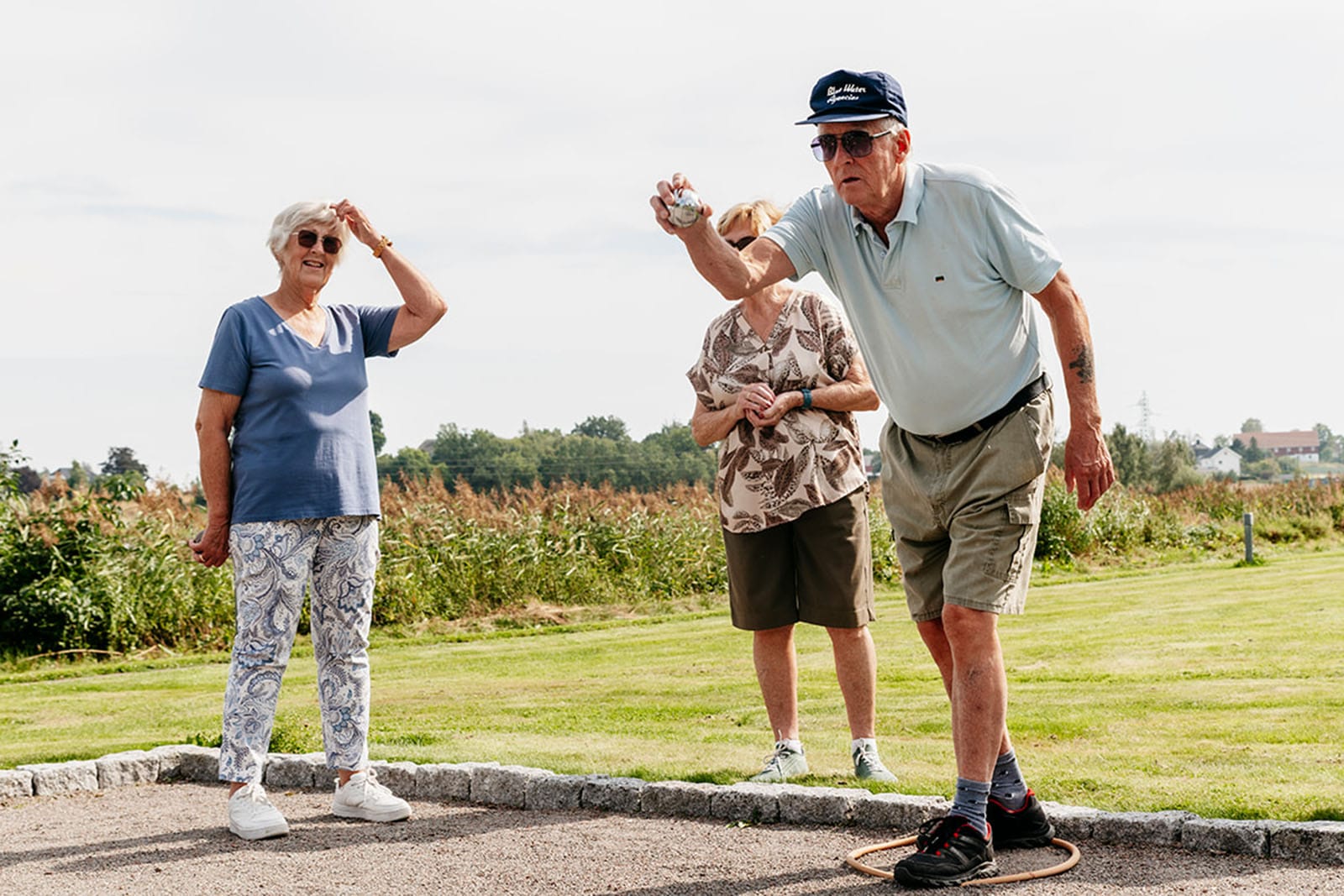 To menn spiller Petanque på en gressplen